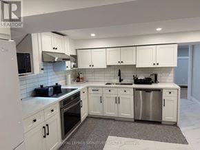 Toronto (Willowridge-Martingrove-Richview) apartment for rent - A white kitchen with a refrigerator, oven, and sink.