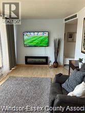 Windsor condo for rent - A living room with a television and a fireplace.