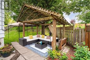 Oshawa (Mclaughlin) apartment for rent - A backyard with a wooden pergola and a patio.