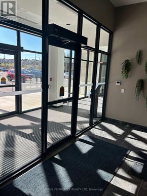Kitchener condo for rent - A glass door with a black frame and a sign that says "REALTOR" on it.