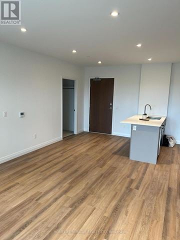 Kitchener condo for rent - A room with wooden flooring and a kitchenette.