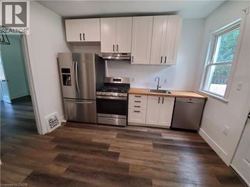 Hamilton apartment for rent - A kitchen with white cabinets and a wooden floor.