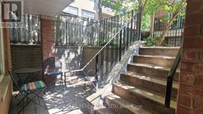 Toronto (Cabbagetown-South St. James Town) townhouse for rent - A patio with a table and chairs is surrounded by a metal fence.