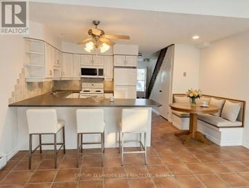 Ramara townhouse for rent - A kitchen with a black counter top and white cabinets.