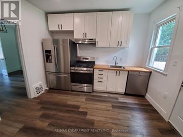 Hamilton (Stipley) apartment for rent - A kitchen with white cabinets and a wooden counter top.