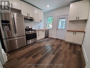 Hamilton (Stipley) apartment for rent - A kitchen with white cabinets and a wooden floor.