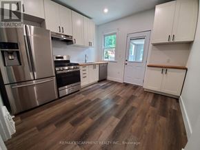 Hamilton (Stipley) apartment for rent - A kitchen with white cabinets and a wooden floor.