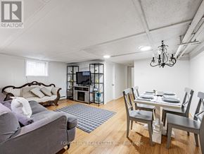 Toronto (The Beaches) apartment for rent - A living room with a grey couch and a white dining table.