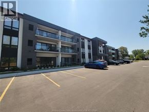 Kingsville condo for rent - A parking lot in front of a multi-story apartment building.