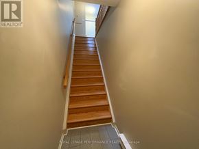 Ottawa condo for rent - A staircase with wooden steps and a white wall on the side.