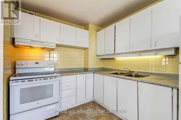 Toronto (Flemingdon Park) condo for rent - A kitchen with white cabinets and a stove top oven.