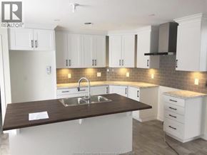 Wendover townhouse for rent - A kitchen with white cabinets and a brown countertop.