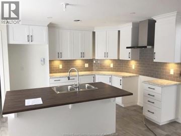 Wendover townhouse for rent - A kitchen with white cabinets and a brown countertop.