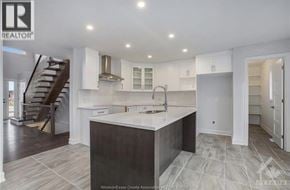Wendover townhouse for rent - A modern kitchen with a large island and a staircase in the background.