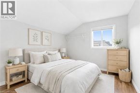 Hamilton apartment for rent - A bedroom with a bed, nightstand, and a window.