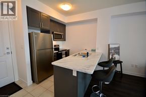 Waterdown condo for rent - A kitchen with a refrigerator, microwave, and a counter.