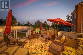 Vaughan (Vellore Village) apartment for rent - A patio with a couch, chairs, and umbrellas is set up for relaxation.