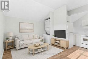 Hamilton (Strathcona) apartment for rent - A living room with a white couch, a wooden coffee table, and a television on a wooden stand.