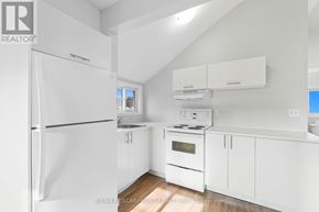 Hamilton (Strathcona) apartment for rent - A white kitchen with a refrigerator, oven, and cabinets.