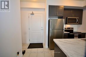 Hamilton (Waterdown) condo for rent - A kitchen with a refrigerator, microwave, and oven.