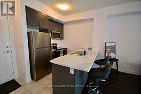 Hamilton (Waterdown) condo for rent - A kitchen with a refrigerator, microwave, and oven.