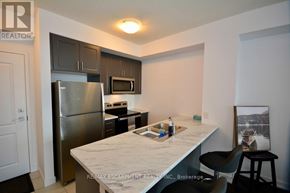 Hamilton (Waterdown) condo for rent - A kitchen with a refrigerator, microwave, and a counter top.