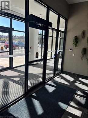 Kitchener condo for rent - A glass door with a black frame and a black mat on the floor.