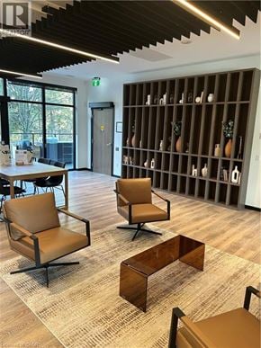 Kitchener condo for rent - A room with a wooden floor and a shelf with bottles on it.