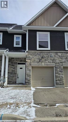 Woodstock townhouse for rent - A house with a stone wall and a garage door.
