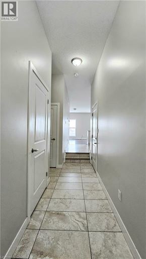 Woodstock townhouse for rent - A long hallway with white doors and tiled floors.