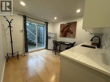 Vancouver apartment for rent - A kitchen with a white counter top and a painting of a horse on the wall.