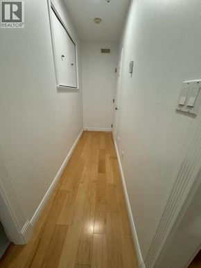 Vancouver apartment for rent - A long hallway with wood floors and white walls.