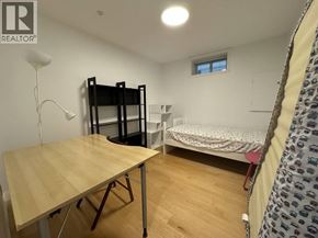 Vancouver apartment for rent - A room with a bunk bed, a single bed, and a table.