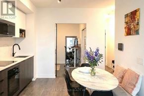 Toronto (Regent Park) condo for rent - A modern kitchen with a dining table set for two.