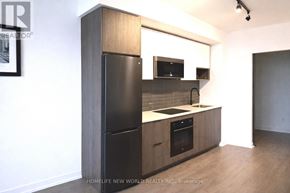 Toronto (Regent Park) condo for rent - A kitchen with a black refrigerator, microwave, and oven.
