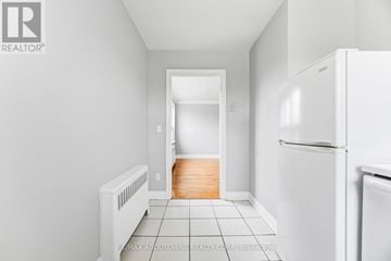 Oakville (Cp College Park) apartment for rent - A white refrigerator sits in a kitchen with white walls and tile flooring.