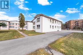 Oakville (Cp College Park) apartment for rent - A white building with a tree in front of it and a blue sky in the background.