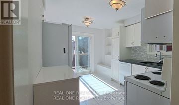 Oakville (Ro River Oaks) apartment for rent - A kitchen with white cabinets and a black stove top oven.