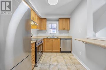 Pickering (Town Centre) townhouse for rent - A kitchen with wooden cabinets and a stainless steel refrigerator.