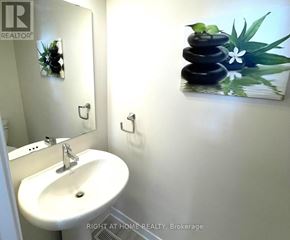 Ottawa townhouse for rent - A bathroom with a sink and a picture of a stack of stones.