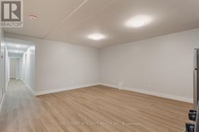 Toronto (Palmerston-Little Italy) apartment for rent - A spacious room with wooden flooring and white walls, likely a property for sale or rent.