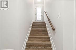 The Nation fourplex for rent - A staircase with wooden steps and a white wall.