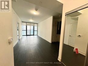 Vaughan (Concord) condo for rent - A spacious room with a large window and a door leading to another room.