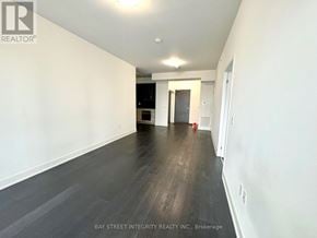 Vaughan (Concord) condo for rent - A long hallway with a white wall and a black door at the end.