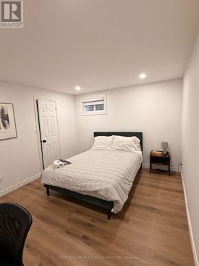 Toronto (West Humber-Clairville) apartment for rent - A bedroom with a bed, chair, and a small table.