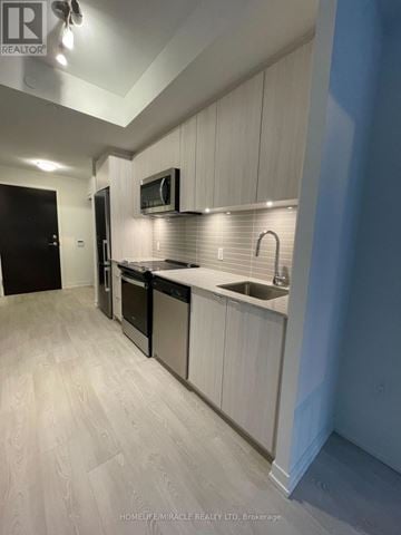 Richmond Hill (South Richvale) condo for rent - A modern kitchen with white cabinets and stainless steel appliances.