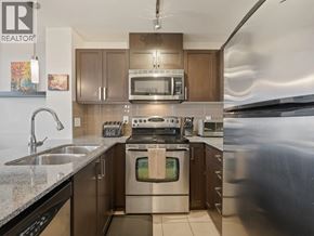 New Westminster apartment for rent - A modern kitchen with stainless steel appliances and wooden cabinets.