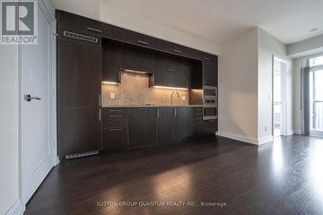 Toronto (Willowdale East) condo for rent - A modern kitchen with dark wood cabinets and a countertop.