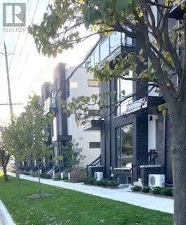 Toronto (Islington-City Centre West) condo for rent - A modern building with glass windows and a tree in front.