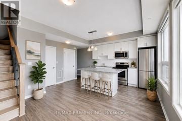 Toronto (Islington-City Centre West) condo for rent - A modern kitchen with white cabinets and a center island.